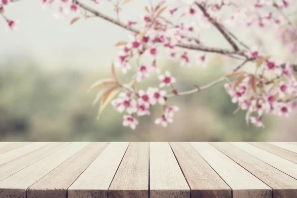 Empty top wooden table and flower field blurred background