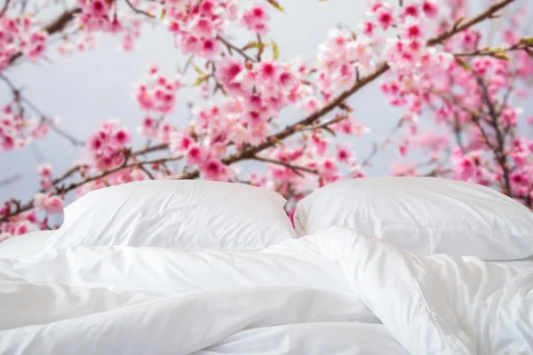 Sábanas blancas y almohada sobre fondo abstracto borroso —  Fotos de Stock