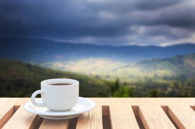 Kahve fincanı ahşap masa ve dağ manzarası 