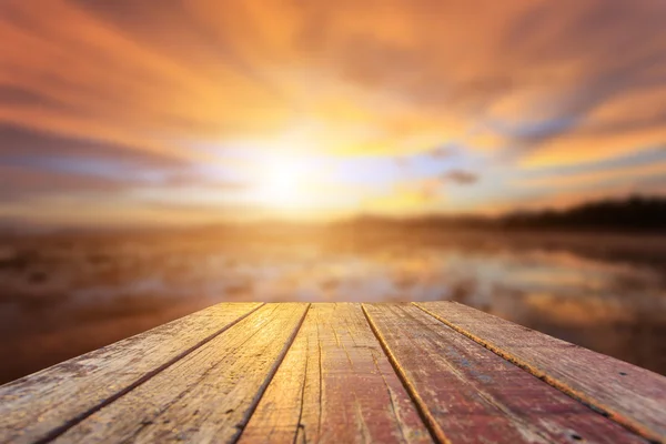Top van oude houten tafel met zonsondergang achtergrond vervagen — Stockfoto