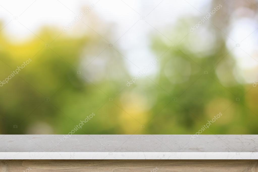 Empty top of granite stone table or counter on blurred green bac