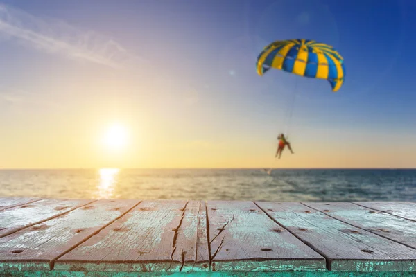 Lege top van houten tafel en uitzicht op tropisch strand achtergrond — Stockfoto