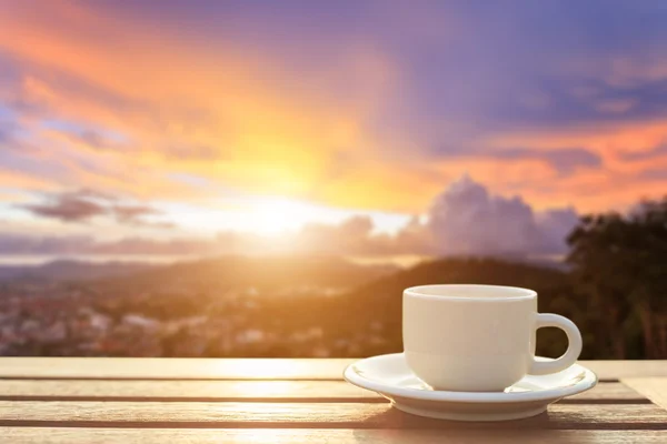 Kaffeetasse auf Holztisch bei Sonnenuntergang oder Sonnenaufgang — Stockfoto