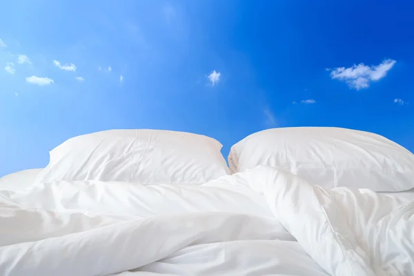 Biancheria da letto bianca e cuscino in vista di sfondo cielo — Foto Stock