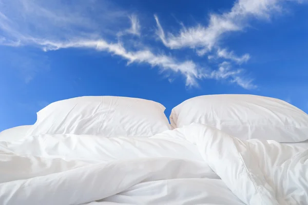 White bedding sheets and pillow on view of sky background — Stock Photo, Image