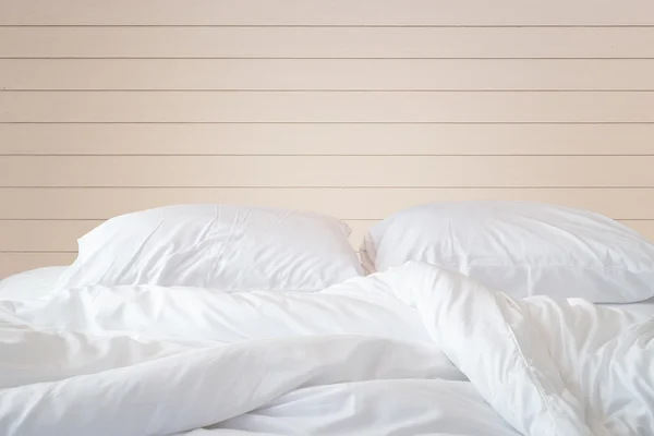 Sábanas blancas y almohada sobre fondo de pared de madera , —  Fotos de Stock