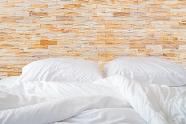 Белые простыни и подушки на натуральной каменной стене — стоковое фото