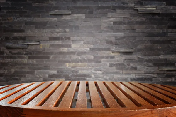 空の上の木製のテーブルと石の壁の背景 — ストック写真