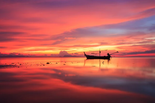 Silueta tradicional barco de cola larga y hermoso cielo rojo y s — Foto de Stock