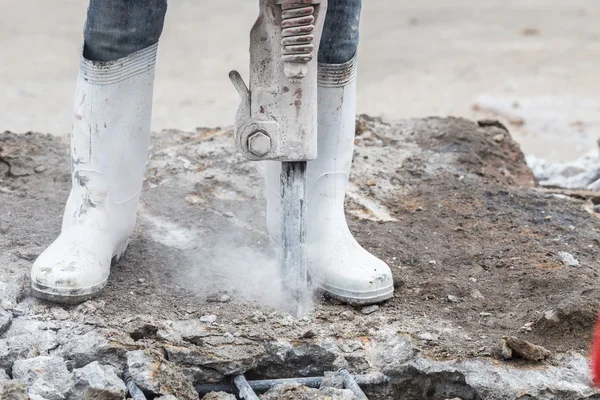 Bouwvakker verwijdert overtollige beton met boren machin — Stockfoto