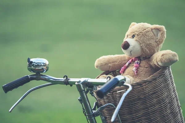 Precioso osito de peluche marrón en canasta de ratán en bicicleta vintage en gree — Foto de Stock