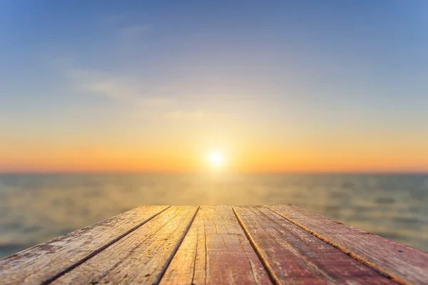 Top van oude houten tafel met zonsondergang achtergrond vervagen — Stockfoto