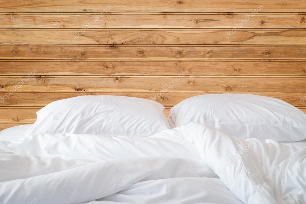 Beyaz çarşaf ve yastık ahşap duvar Oda arka plan üzerinde