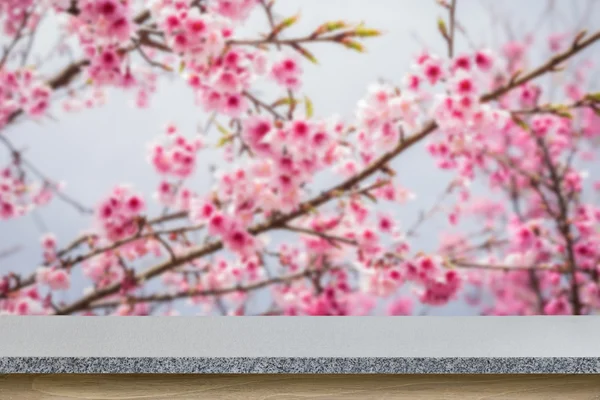 Tisch oder Theke aus Naturstein auf verschwommenem Blumenhintergrund — Stockfoto