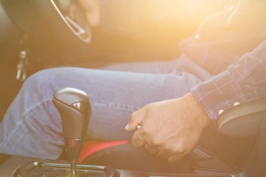 Araba kullanma konsepti: modern arabanın içinde el frenini çek. Arabanın içi sabah altın güneş ışığı etkisiyle aydınlandı. Ulaşım kullanımı