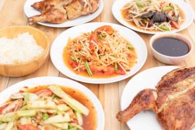 Masanın üzerinde papaya salatası ve baharatlı salata seti var. Tayland tarzı yemek konsepti