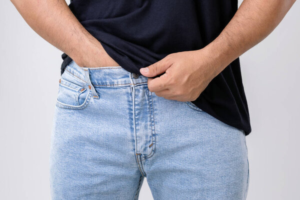 Pain on penis concept : Man use his hands to press on his penis on grey background. Used for Prostate cancer