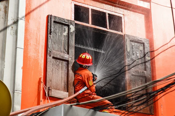 消防士の火災を防ぐために水ホースを使用します。 — ストック写真