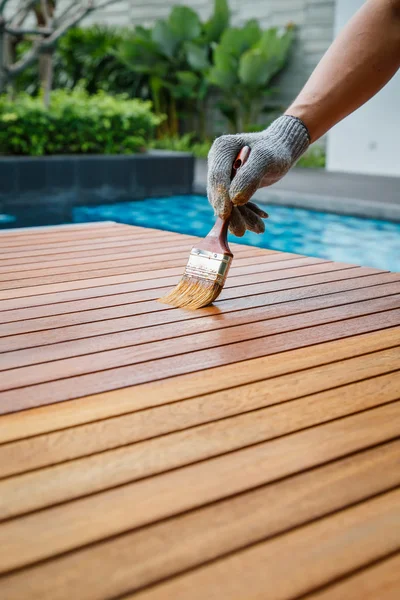 Pincel en mano y pintura sobre la mesa de madera — Foto de Stock