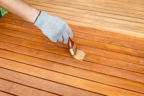 Brush in hand and painting on the wooden table — Stock Photo, Image