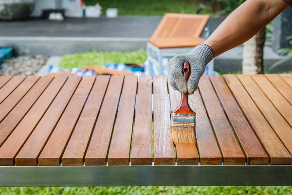 Brush in hand and painting on the wooden table — Stock Photo, Image