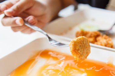 Kızarmış tavuk nuggets tutarak ve restoranda yemek el