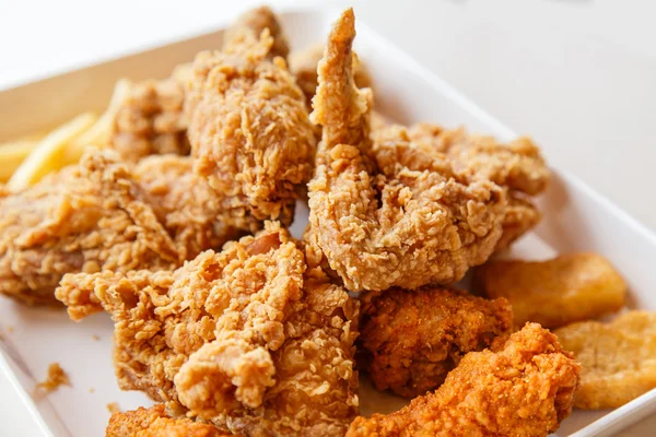 Ręką trzyma Fried chicken nuggets i jedzenie w restauracji — Zdjęcie stockowe
