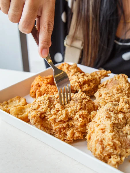 Ręką trzyma Fried chicken nuggets i jedzenie w restauracji — Zdjęcie stockowe