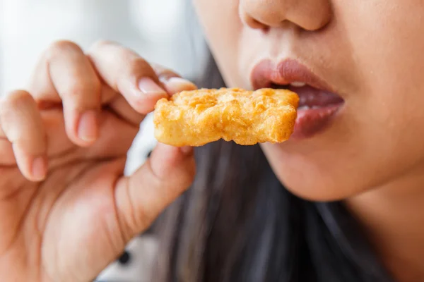 Mano sosteniendo nuggets de pollo frito y comiendo en el restaurante —  Fotos de Stock