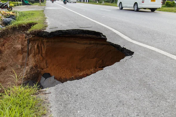 Collapse of the road. Condition of the road to water erosion as — Stock Photo, Image