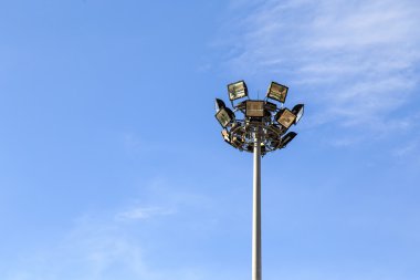 Stadyumda mavi gökyüzü ile spot ışık kutup