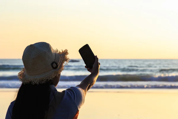 Mujer tailandesa usando smartphone en la playa — Foto de Stock