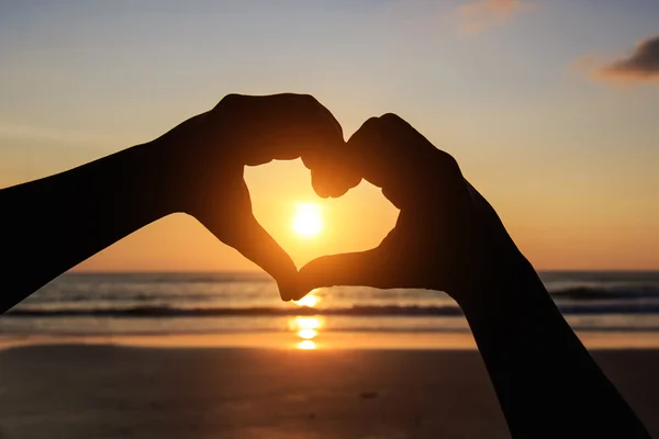 Silhuett av händer i hjärtsymbol runt solen — Stockfoto