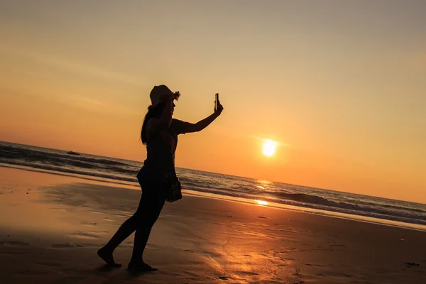 Silhouette di Thai Woman utilizzando smartphone in spiaggia al tramonto — Foto Stock
