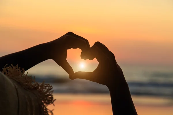 Silhouette delle mani nel simbolo del cuore intorno al sole — Foto Stock