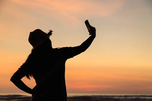 Silhouette de Thai Woman en utilisant un smartphone à la plage au coucher du soleil — Photo