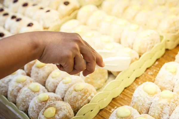 Hand holding Serving kitchen tongs in bakery shop — Stock Photo, Image