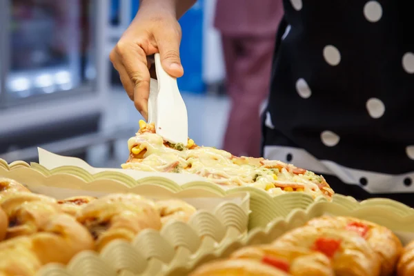 Hand holding Serving kitchen tongs in bakery shop — Stock Photo, Image