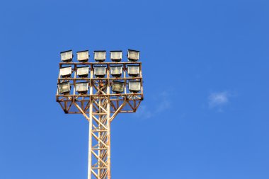 Stadyumda mavi gökyüzü ile spot ışık kutup
