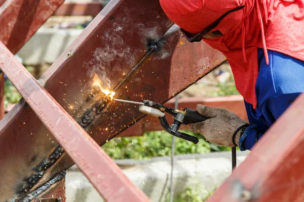 Mies hitsaamassa terästä rakennustyömaalla. — kuvapankkivalokuva