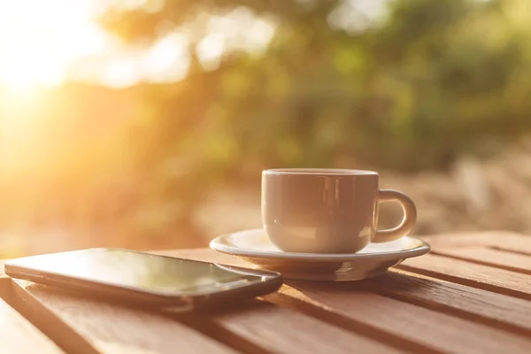 Una taza de café y teléfono inteligente sobre la mesa —  Fotos de Stock