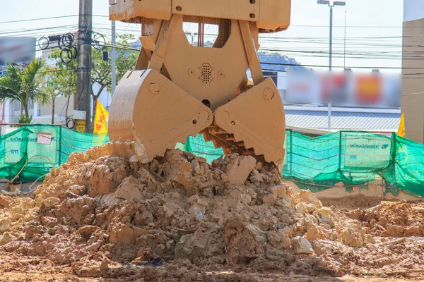Excavatrice en action creuser le sol — Photo