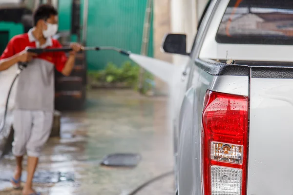 Flou de l'homme utilisant un nettoyeur sous pression pour laver une voiture — Photo