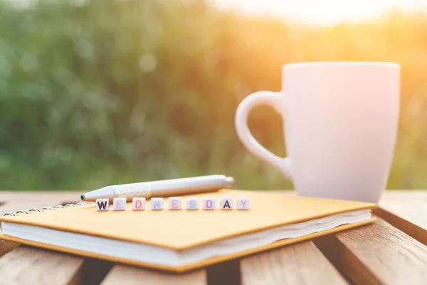 Onsdag skrivet i brevet pärlor och en kaffekopp på tabell — Stockfoto