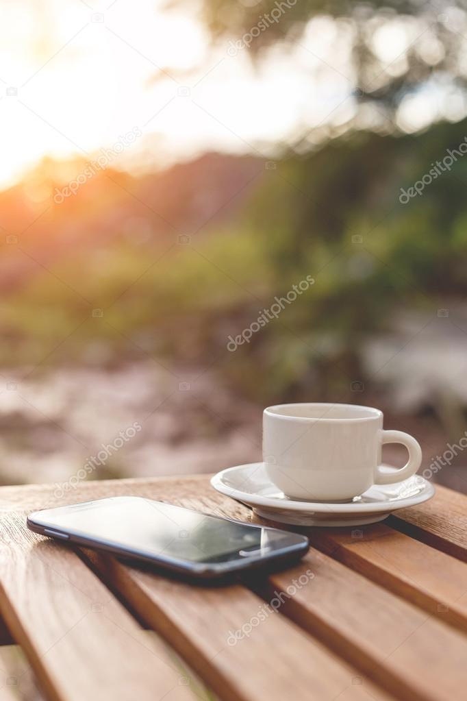 A cup of coffee and smartphone on the table