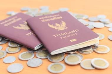 Tayland Passport'u kapatın ve masaya sikke