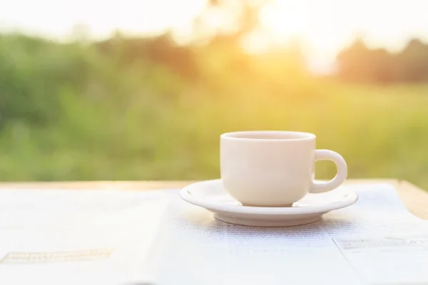 Kaffeetasse und Zeitung morgens auf den Tisch legen — Stockfoto