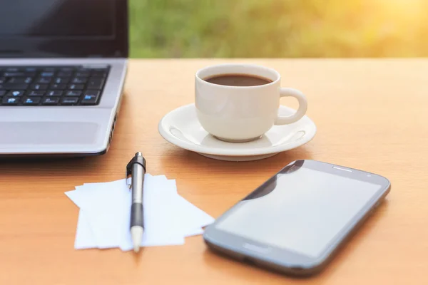 Cierre la taza de café y el portátil en la mesa por la mañana — Foto de Stock