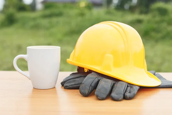 Nära håll kaffe kopp och hjälm på bordet — Stockfoto