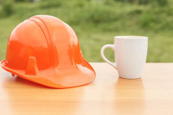 Kaffeetasse und Schutzhelm aus nächster Nähe auf dem Tisch — Stockfoto